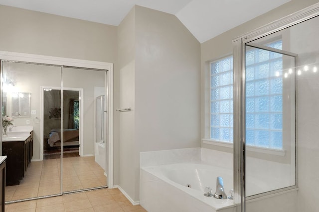 606 Indian Run Dr, Pflugerville, TX 78660 - ensuite bathroom with vanity, a whirlpool tub, tile patterned floors, healthy amount of natural light, and vaulted ceiling