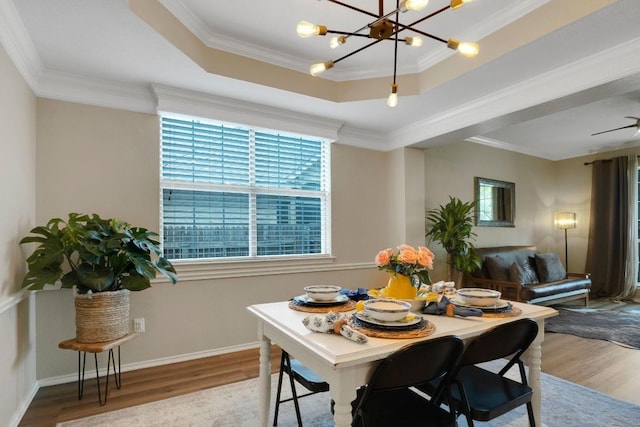 606 Indian Run Dr, Pflugerville, TX 78660 - dining room featuring wood finished floors, a chandelier, crown molding, and a raised ceiling
