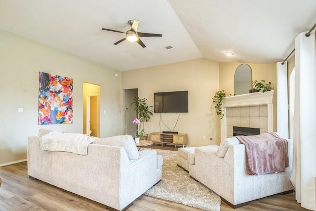 606 Indian Run Dr, Pflugerville, TX 78660 - living area with ceiling fan, wood finished floors, a tiled fireplace, and vaulted ceiling