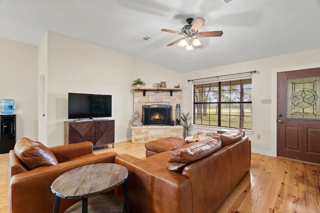 3434 Prairie Lea Rd, Kingsbury, TX 78638 - living room with lofted ceiling, light wood-type flooring, a stone fireplace, and a ceiling fan