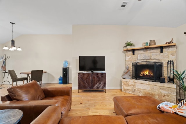 3434 Prairie Lea Rd, Kingsbury, TX 78638 - living room featuring a chandelier, light wood-style flooring, lofted ceiling, and a stone fireplace