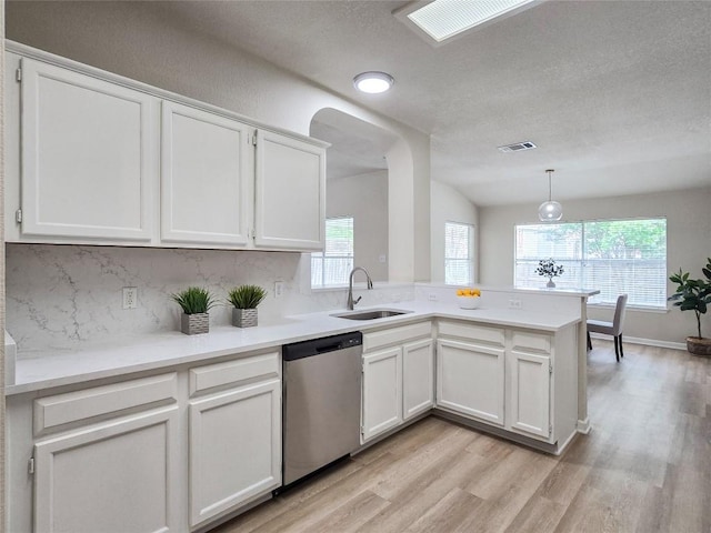 9403 Tea Rose Trl, Austin, TX 78748 - kitchen with stainless steel dishwasher, a sink, light wood finished floors, white cabinetry, and a textured ceiling