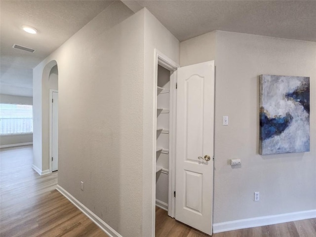 9403 Tea Rose Trl, Austin, TX 78748 - corridor featuring arched walkways, wood finished floors, and baseboards