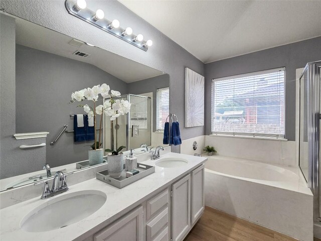 9403 Tea Rose Trl, Austin, TX 78748 - bathroom with a bath, a shower stall, wood finished floors, and double vanity