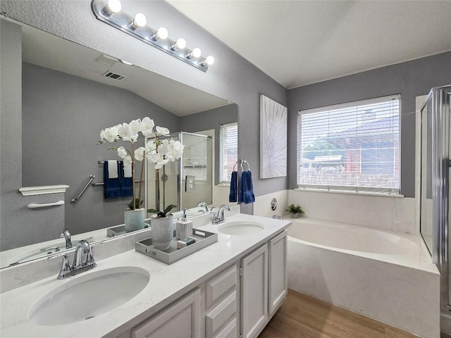 9403 Tea Rose Trl, Austin, TX 78748 - bathroom featuring a garden tub, a shower stall, wood finished floors, and double vanity