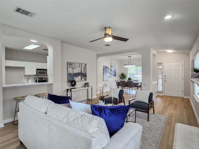 9403 Tea Rose Trl, Austin, TX 78748 - living area featuring arched walkways, light wood-type flooring, baseboards, a ceiling fan, and recessed lighting