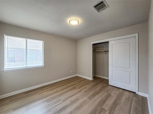 9403 Tea Rose Trl, Austin, TX 78748 - unfurnished bedroom featuring wood finished floors, baseboards, a textured ceiling, and a closet