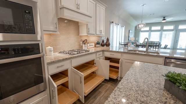 108 Berkeley Pl, Georgetown, TX 78628 - kitchen featuring stainless steel appliances, a sink, a ceiling fan, backsplash, and white cabinetry