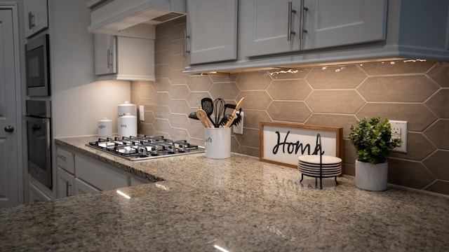 108 Berkeley Pl, Georgetown, TX 78628 - kitchen featuring stainless steel appliances, premium range hood, tasteful backsplash, light stone counters, and gray cabinetry