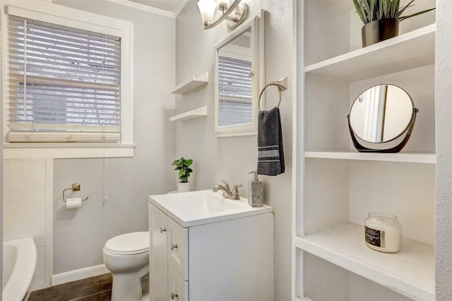 1309 E 13th St, Austin, TX 78702 - bathroom featuring toilet, vanity, a tub, baseboards, and crown molding