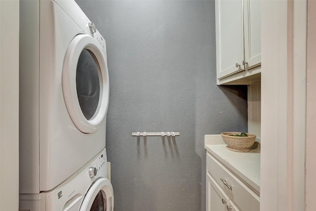 1309 E 13th St, Austin, TX 78702 - washroom featuring stacked washer and clothes dryer, cabinet space, and a textured wall