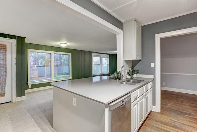 1309 E 13th St, Austin, TX 78702 - kitchen with stainless steel dishwasher, a sink, white cabinets, baseboards, and light countertops