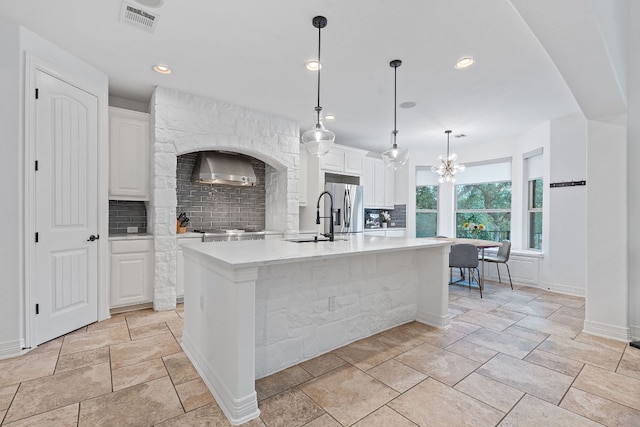 7609 Lazy River Cv, Austin, TX 78730 - kitchen with stainless steel fridge with ice dispenser, a sink, decorative backsplash, wall chimney exhaust hood, and light countertops