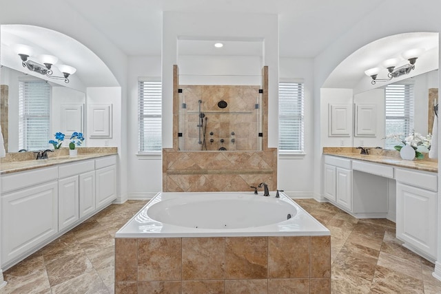 7609 Lazy River Cv, Austin, TX 78730 - bathroom featuring a whirlpool tub, two vanities, tiled shower, and baseboards