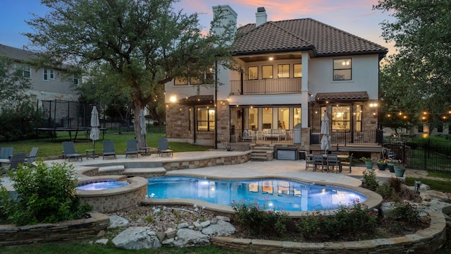 7609 Lazy River Cv, Austin, TX 78730 - rear view of house with a balcony, a trampoline, a patio, and a tiled roof