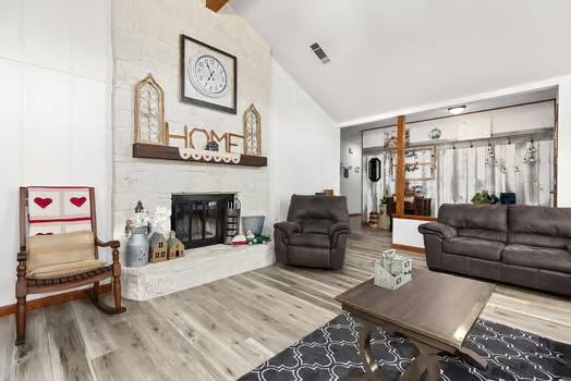 2305 Canyon Creek Dr, Temple, TX 76502 - living room with a large fireplace, wood finished floors, and high vaulted ceiling