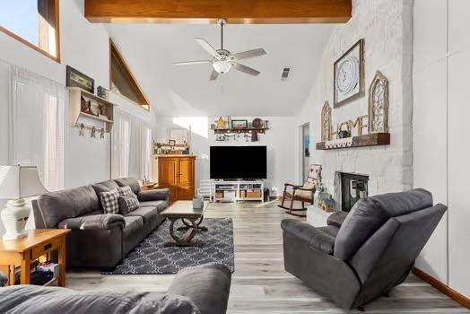 2305 Canyon Creek Dr, Temple, TX 76502 - living area with high vaulted ceiling, beam ceiling, a ceiling fan, a large fireplace, and light wood-style flooring