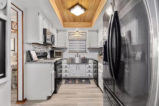 2305 Canyon Creek Dr, Temple, TX 76502 - kitchen with refrigerator with ice dispenser, electric range oven, wood ceiling, a sink, and white cabinets