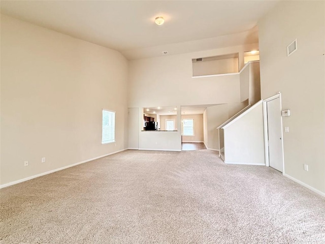 110 Carbine Ct, Bastrop, TX 78602 - unfurnished living room featuring carpet, baseboards, high vaulted ceiling, and stairs