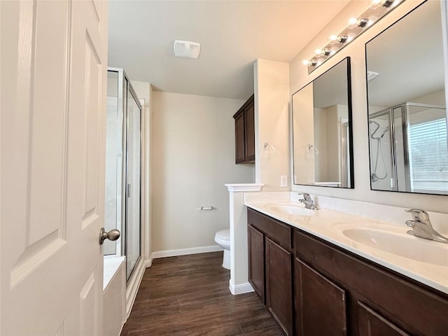 110 Carbine Ct, Bastrop, TX 78602 - full bathroom featuring double vanity, a shower stall, toilet, baseboards, and wood finished floors