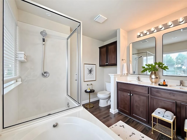 110 Carbine Ct, Bastrop, TX 78602 - full bathroom featuring a stall shower, wood finished floors, toilet, double vanity, and a garden tub