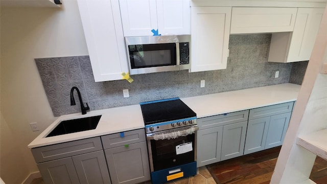 1134 Lott Ave, Austin, TX 78721 - kitchen with stainless steel microwave, electric range, a sink, and gray cabinetry