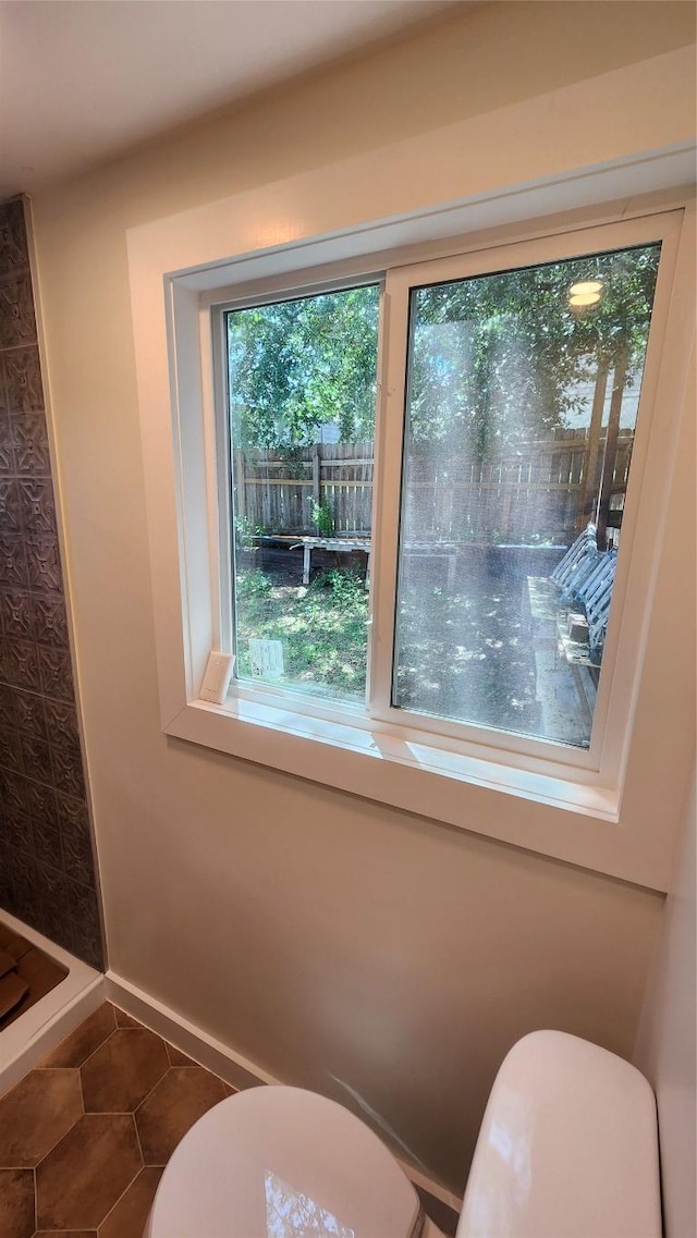 1134 Lott Ave, Austin, TX 78721 - bathroom with toilet, baseboards, tile patterned floors, and a shower