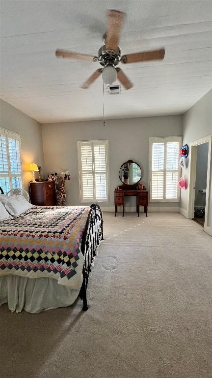 636 Franklin St S, La Grange, TX 78945 - bedroom with multiple windows, light colored carpet, and ceiling fan