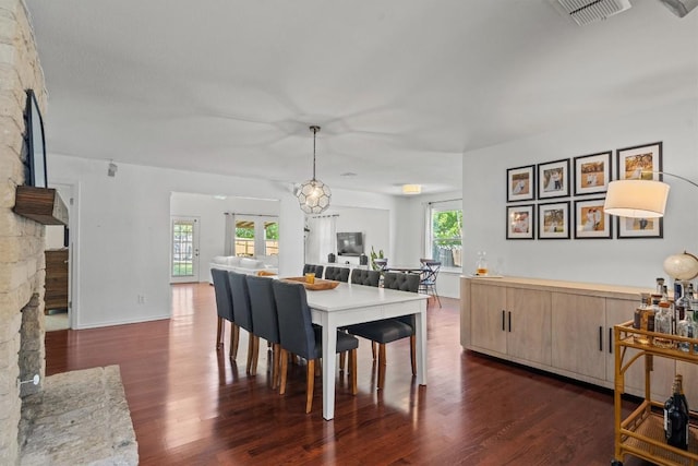 8804 Peppergrass Cv, Austin, TX 78745 - dining area featuring dark wood-type flooring, a fireplace, and baseboards