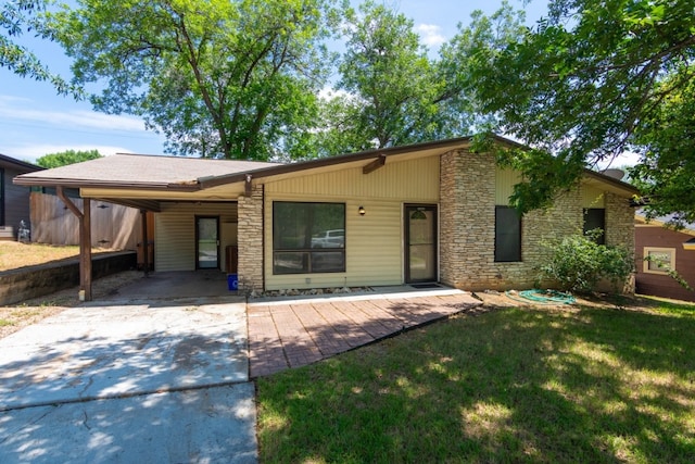 6903 N La Salle Dr, Austin, TX 78723 - mid-century inspired home featuring stone siding, driveway, a carport, and a front yard