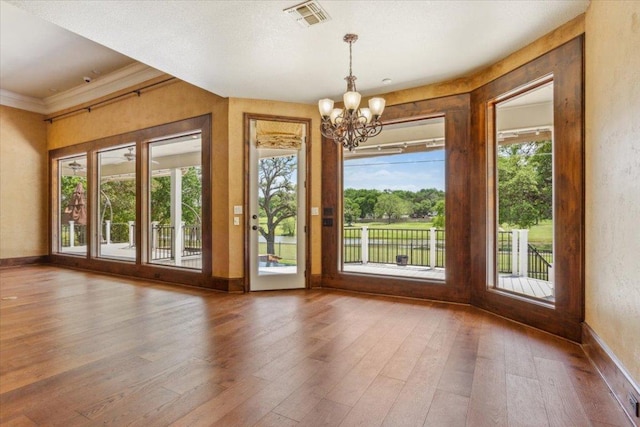 1111 Mill Creek Dr, Salado, TX 76571 - spare room featuring a chandelier, wood-type flooring, and plenty of natural light
