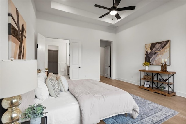 3008 Soldato Way, Leander, TX 78641 - bedroom featuring wood finished floors, a raised ceiling, a towering ceiling, and ceiling fan