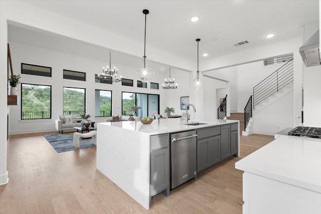 3008 Soldato Way, Leander, TX 78641 - kitchen with appliances with stainless steel finishes, gray cabinetry, open floor plan, light countertops, and a chandelier