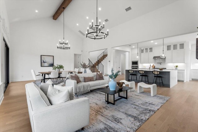 3008 Soldato Way, Leander, TX 78641 - living area with high vaulted ceiling, a chandelier, beamed ceiling, light wood-style floors, and stairway