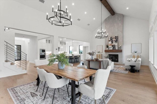 3008 Soldato Way, Leander, TX 78641 - dining space featuring a chandelier, high vaulted ceiling, beam ceiling, light wood-style floors, and stairs