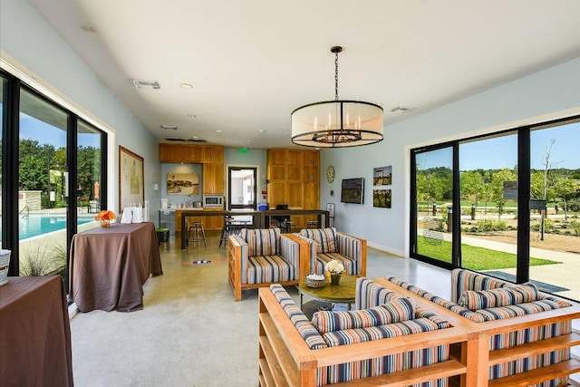 101 Wind Flower Ln, Liberty Hill, TX 78642 - living room featuring finished concrete floors and a chandelier
