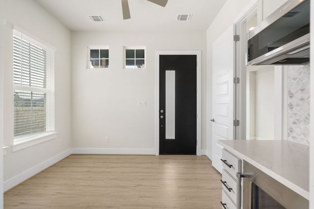 504 Tomichi Trl, Austin, TX 78738 - foyer entrance with light wood finished floors, a ceiling fan, baseboards, and wine cooler