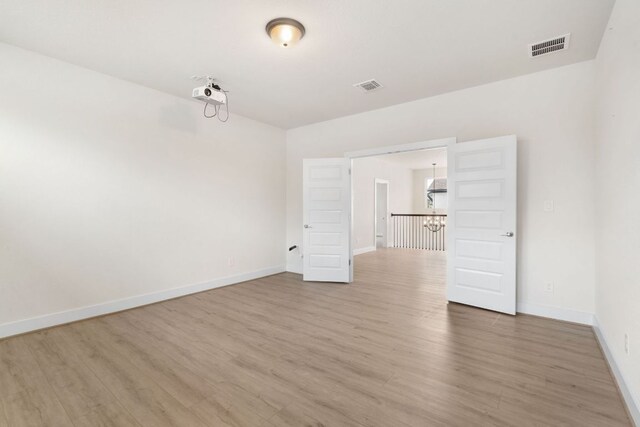 504 Tomichi Trl, Austin, TX 78738 - empty room with a chandelier, light wood-type flooring, and baseboards