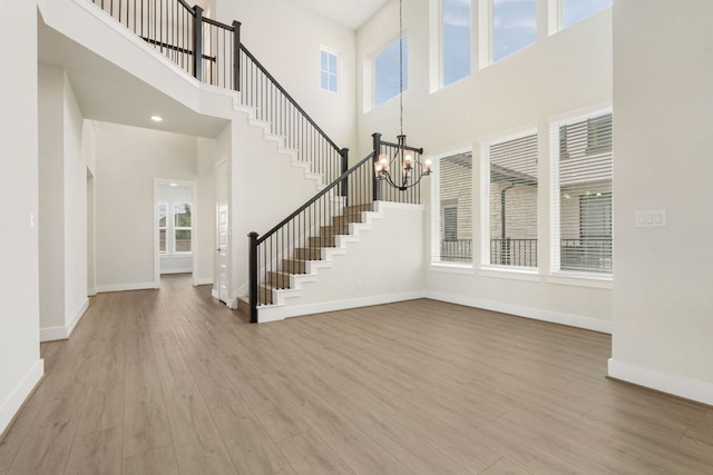 504 Tomichi Trl, Austin, TX 78738 - entryway featuring a towering ceiling, a chandelier, wood finished floors, stairs, and baseboards