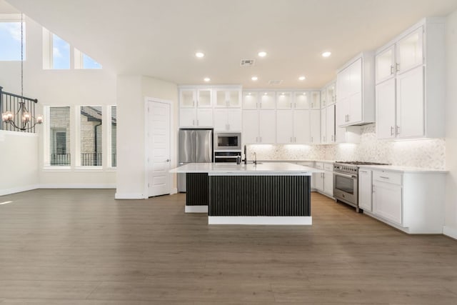 504 Tomichi Trl, Austin, TX 78738 - kitchen featuring appliances with stainless steel finishes, wood finished floors, light countertops, white cabinetry, and recessed lighting
