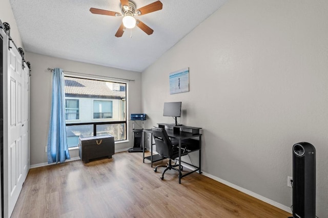 806 W 24th St Unit 302, Austin, TX 78705 - office with vaulted ceiling, wood finished floors, ceiling fan, a barn door, and baseboards