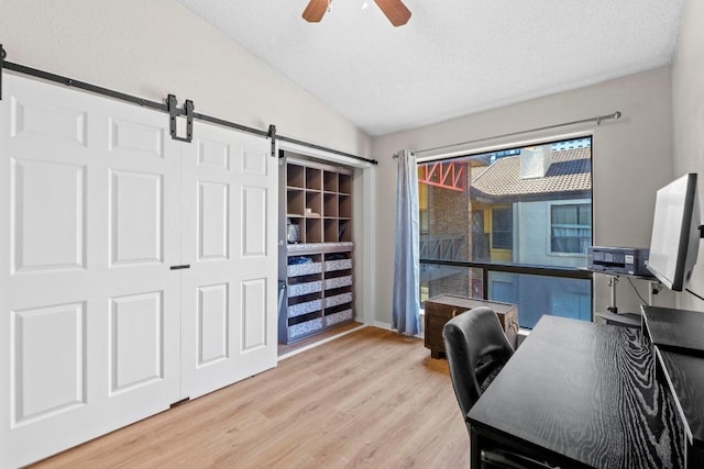 806 W 24th St Unit 302, Austin, TX 78705 - office space with a barn door, a ceiling fan, light wood-style flooring, lofted ceiling, and a textured ceiling