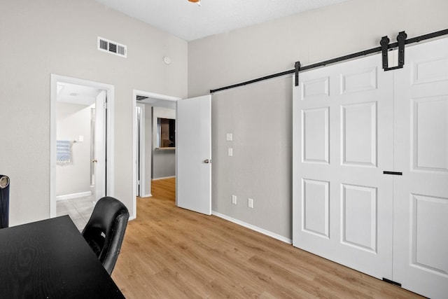 806 W 24th St Unit 302, Austin, TX 78705 - office area featuring a barn door, baseboards, and light wood-style flooring