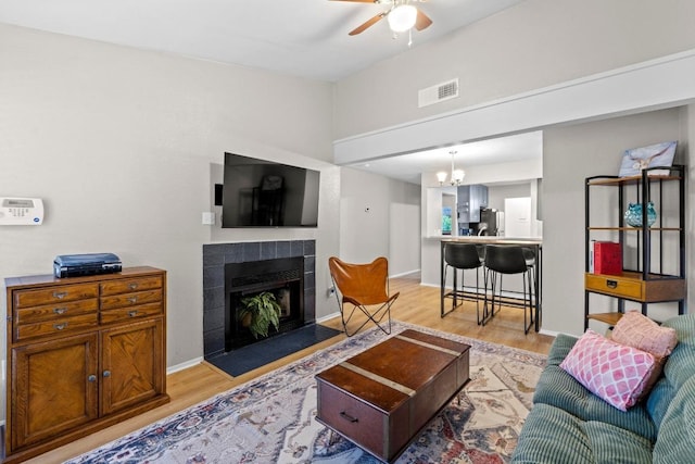 806 W 24th St Unit 302, Austin, TX 78705 - living room with light wood-type flooring, ceiling fan, a tile fireplace, baseboards, and a chandelier