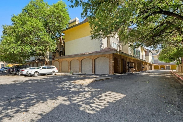 806 W 24th St Unit 302, Austin, TX 78705 - view of front of home featuring stucco siding, a chimney, and uncovered parking