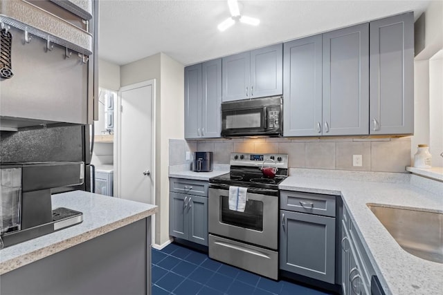 806 W 24th St Unit 302, Austin, TX 78705 - kitchen with black microwave, stainless steel electric stove, decorative backsplash, gray cabinetry, and dark tile patterned floors