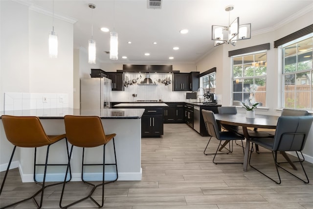 3836 NE Newland Ct, Round Rock, TX 78681 - kitchen featuring freestanding refrigerator, ornamental molding, decorative backsplash, a chandelier, and a peninsula