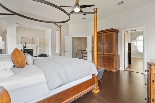3836 NE Newland Ct, Round Rock, TX 78681 - bedroom with dark wood-style floors, a ceiling fan, and a glass covered fireplace