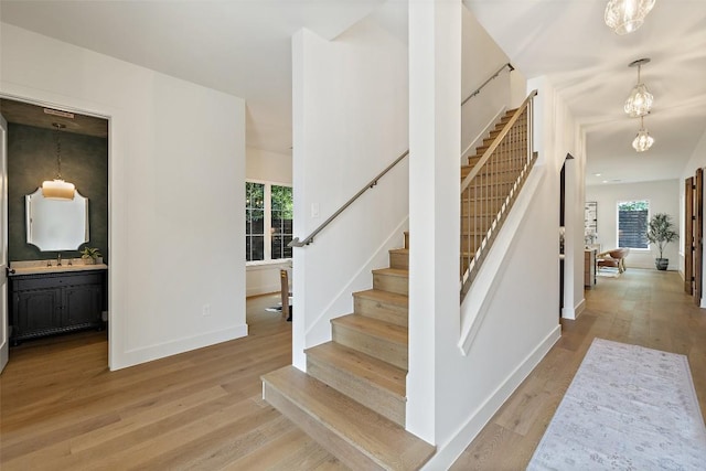 4600 Parkdale Pl Unit 1, Austin, TX 78745 - stairway featuring wood finished floors and a chandelier