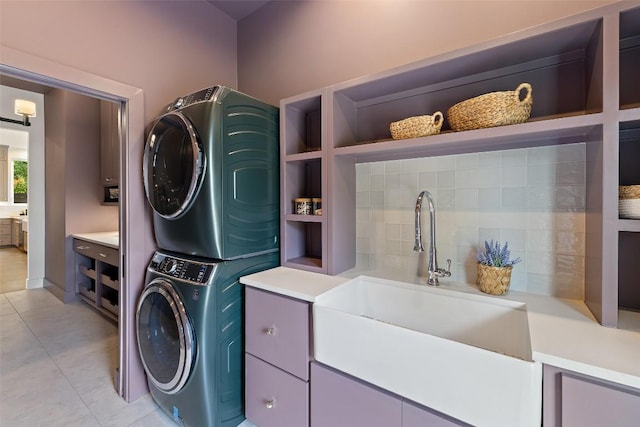 4600 Parkdale Pl Unit 1, Austin, TX 78745 - laundry room featuring stacked washing machine and dryer, light tile patterned floors, and cabinet space